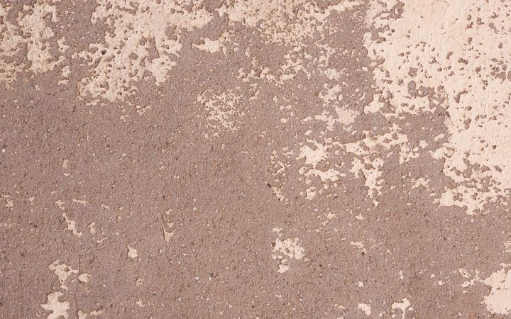 Worn floor surface with patches of old coating flaking away