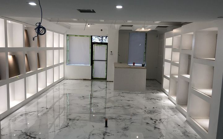 White marble-look metallic floor in a bright retail space with display shelves
