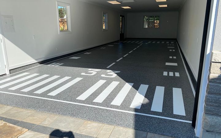 Long shop floor coated dark gray with painted lane stripes and markings